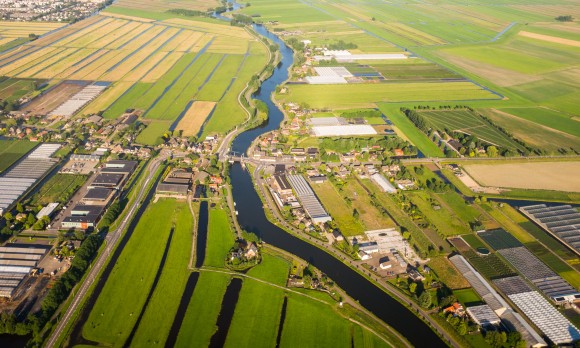 Aerial view over the Amsterdam suburbs with canals, houses , fields and industrial buildings. Holland